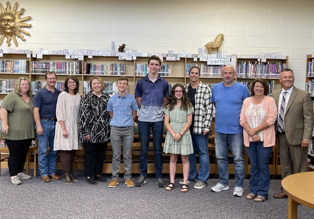 People standing in front of a book case